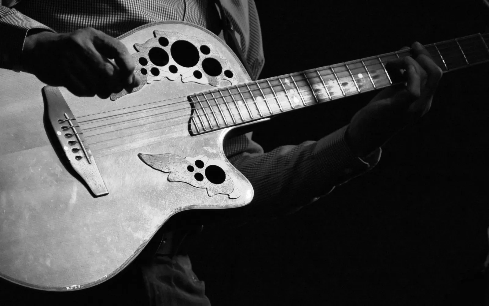 Hands playing an acoustic guitar