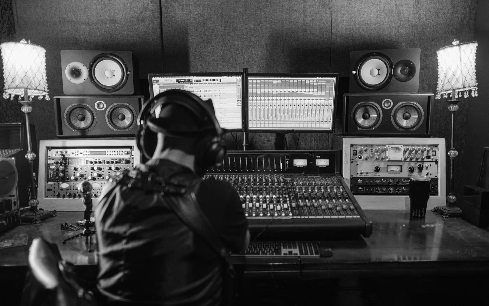 Um produtor musical trabalhando em uma mesa de mixagem em um estúdio de gravação