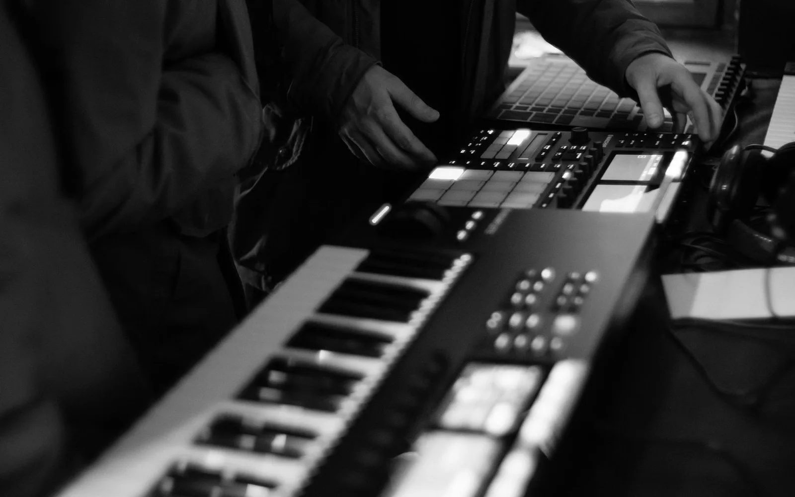 Un producteur travaillant avec un synthétiseur et un pad de batterie dans un studio