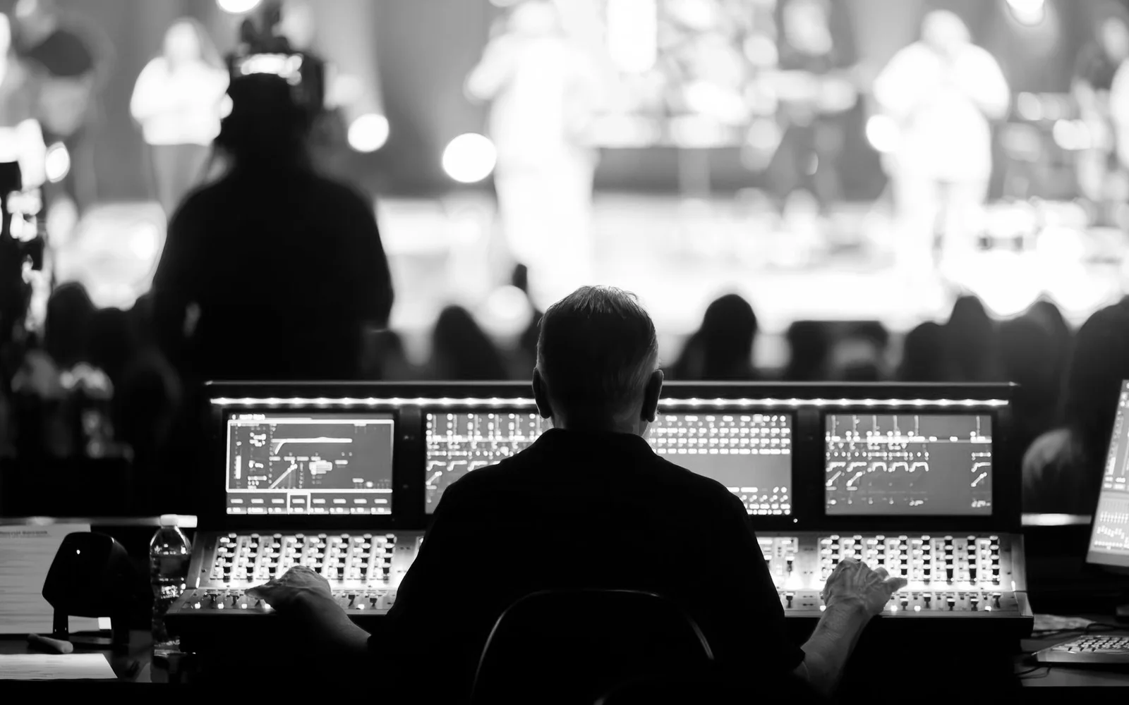 A sound engineer operating a mixing console during a live performance