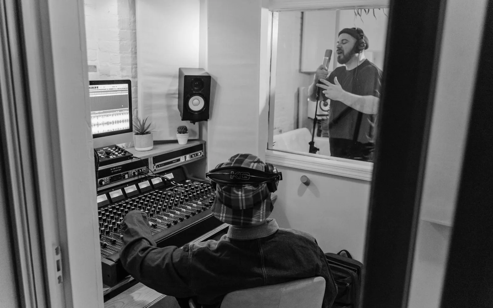 Musicisti che registrano una canzone in uno studio moderno con un ingegnere del suono alla console di missaggio