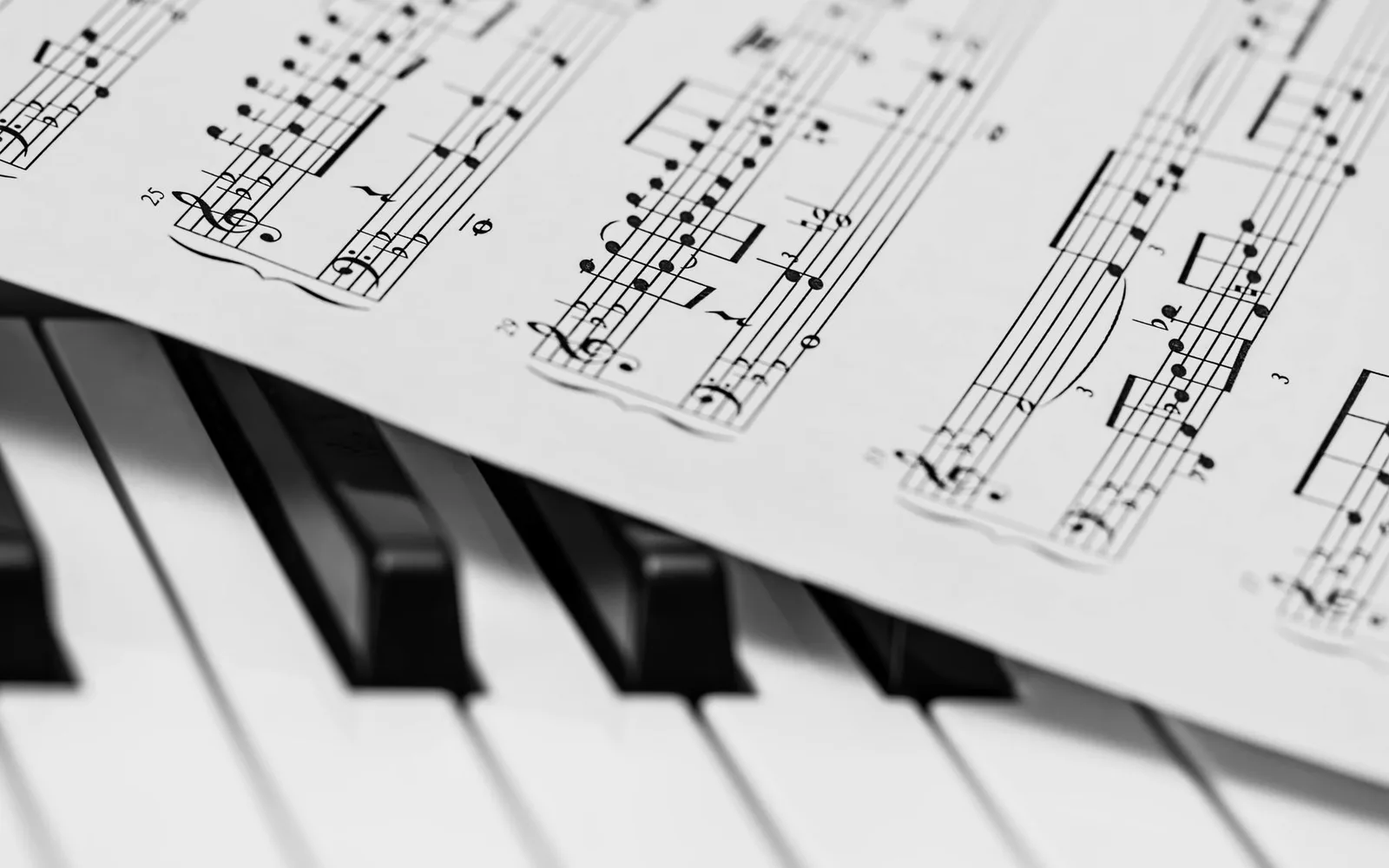 Tasti di pianoforte in bianco e nero con uno spartito di musica classica che crea una composizione armoniosa