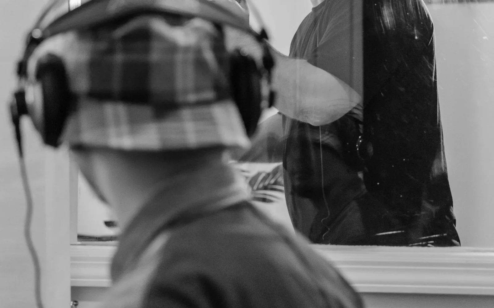 Un produttore musicale supervisiona un cantante che registra le voci in uno studio di registrazione professionale