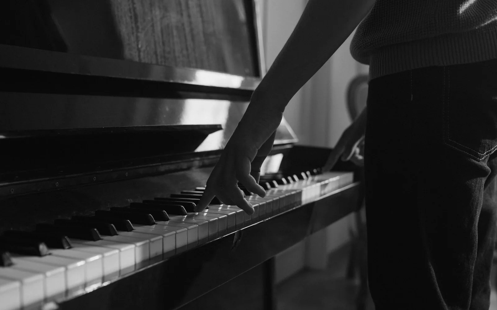 Un musicista che suona un pianoforte verticale