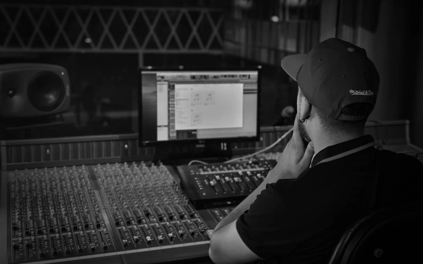Ingegnere del suono al lavoro su una console di missaggio in un accogliente studio di registrazione con illuminazione ambientale