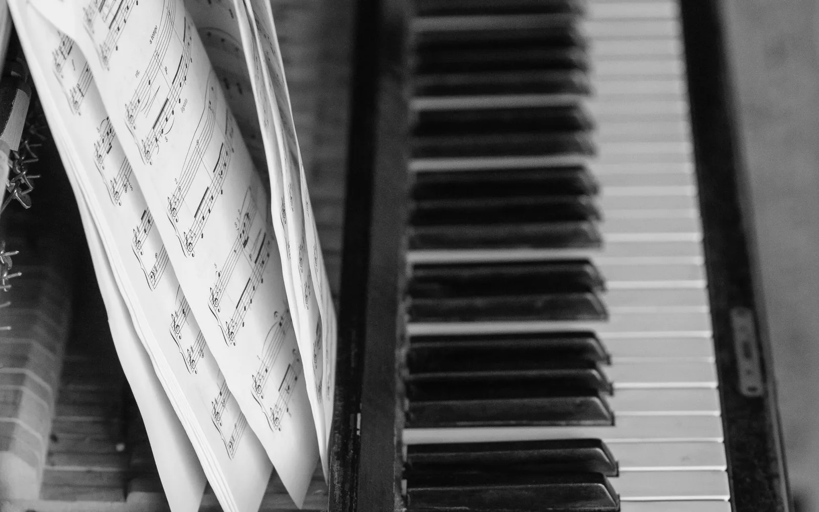 Una vista dettagliata dei tasti di un pianoforte accompagnati da un libro di musica aperto, che mostra l'eleganza musicale.