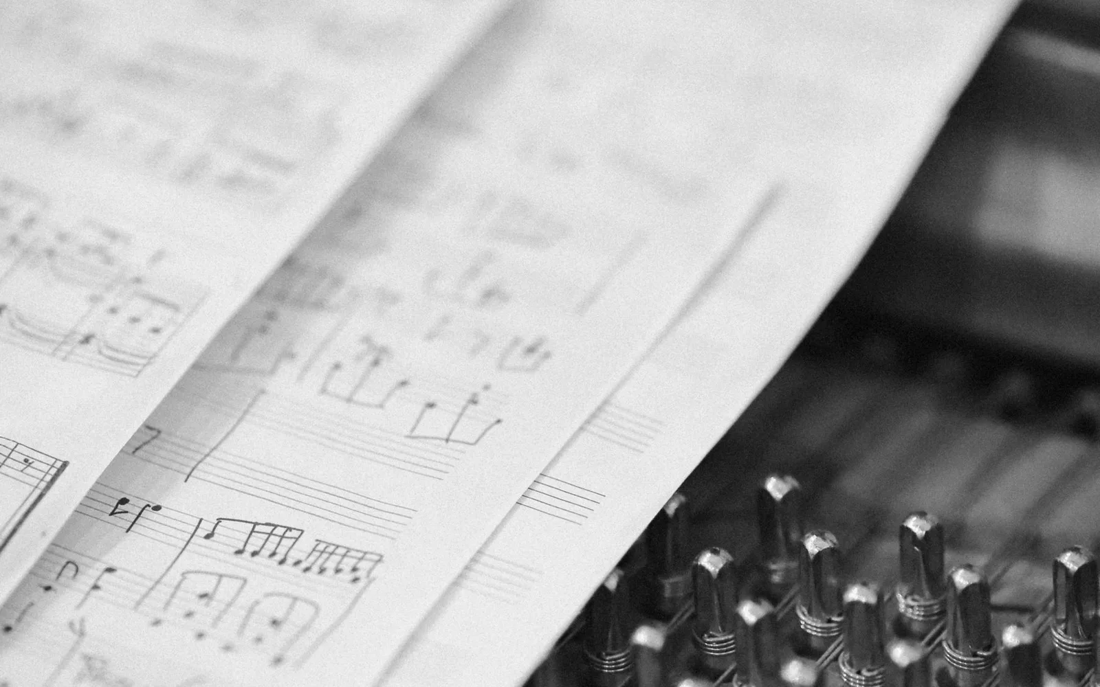 Scatto artistico di spartito dettagliato appoggiato su corde di pianoforte intricate, che trasmette eleganza musicale