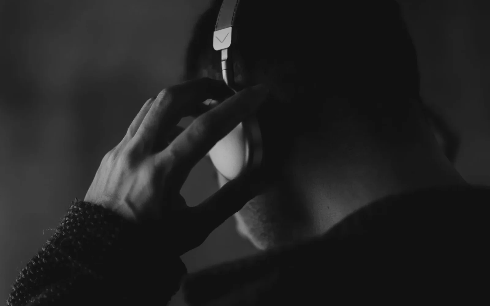 Um homem ouvindo música atentamente com fones de ouvido