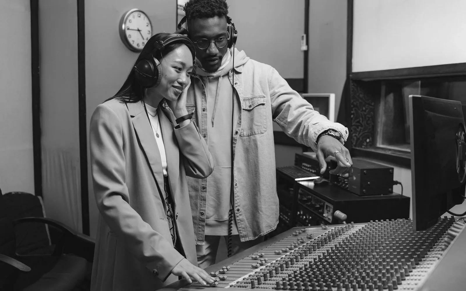 Dois colaboradores revisando equipamentos musicais em um estúdio de gravação