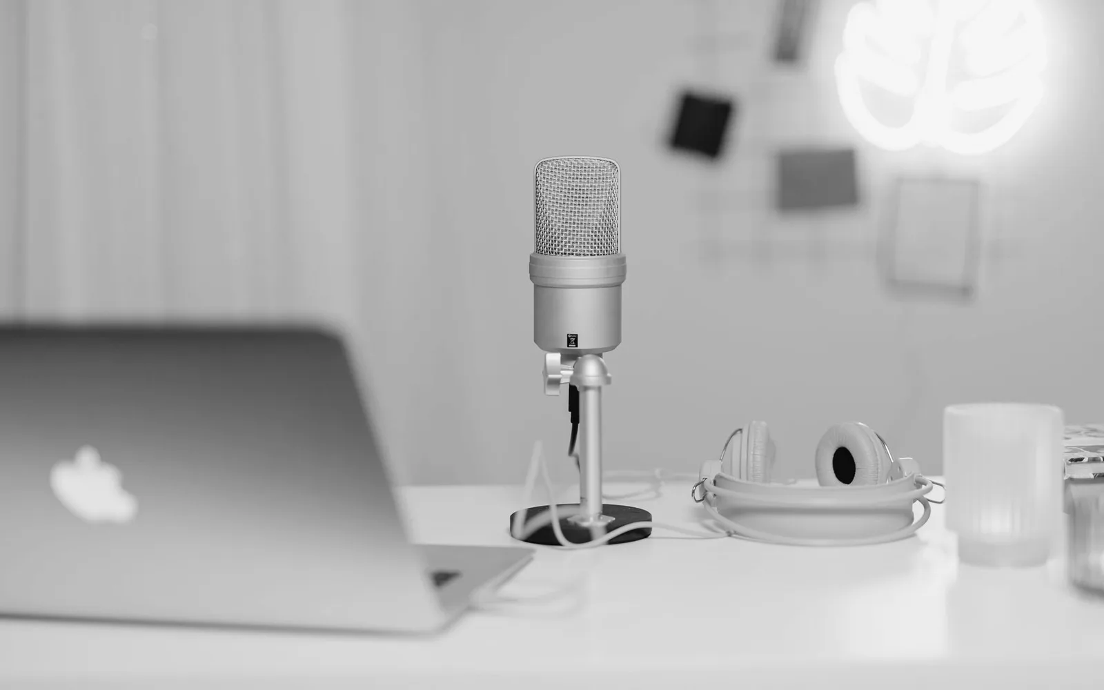Un microphone et un casque à côté d'un ordinateur portable sur un bureau d'enregistrement