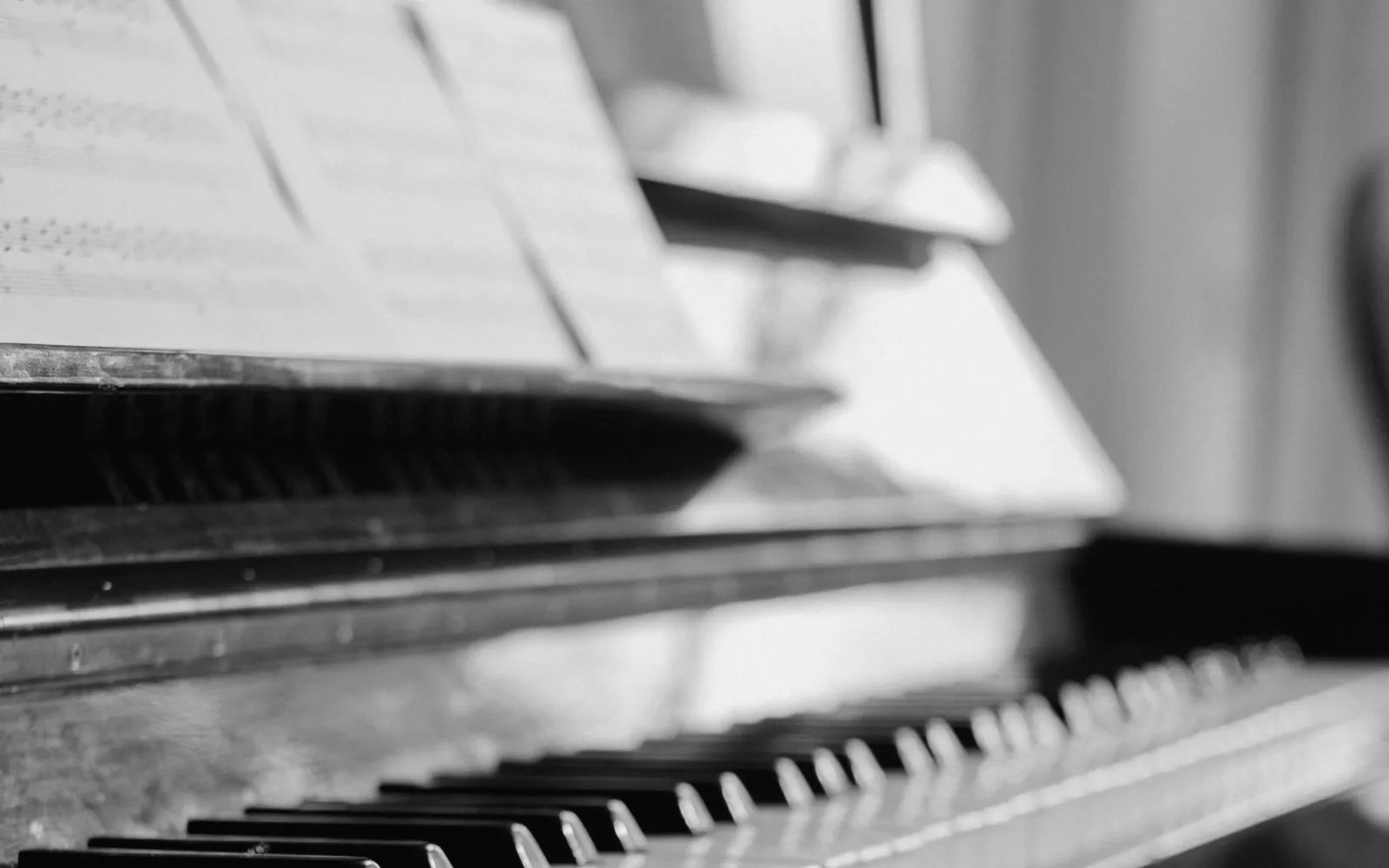 An upright piano with sheet music above its keyboard