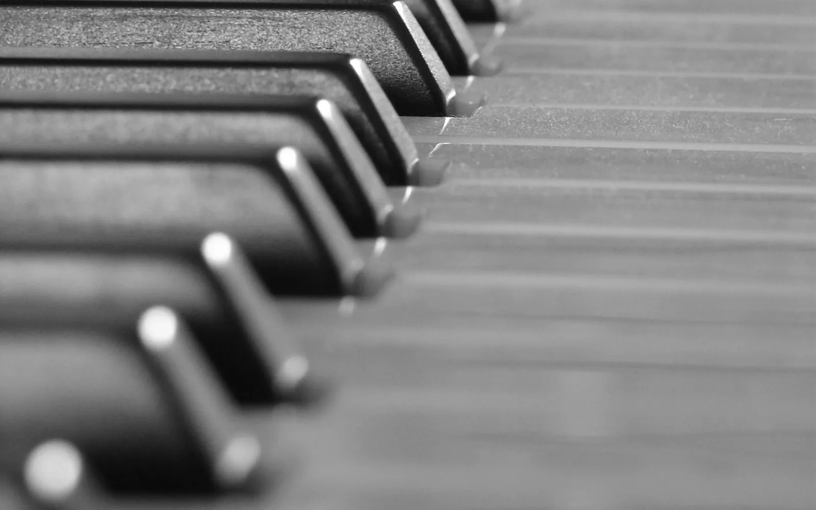 A close view along the black and white keys of a piano