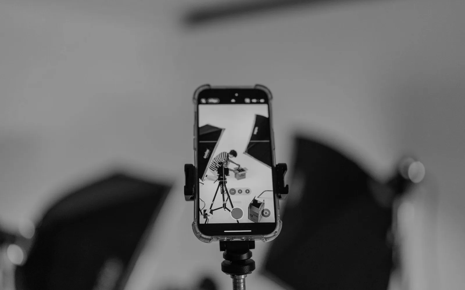 A smartphone on a tripod recording a scene in a studio