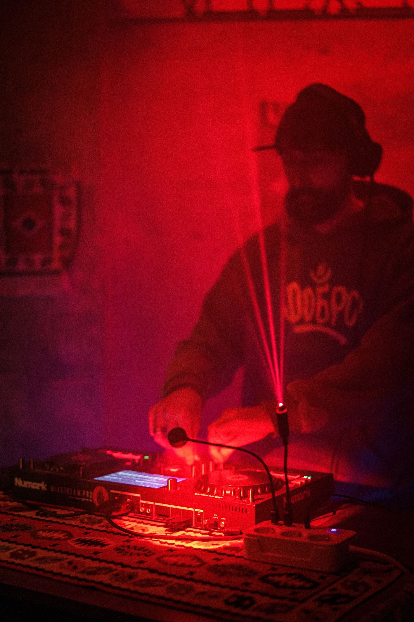 DJ passt ein Mischpult unter einem Laserlichtstrahl an.