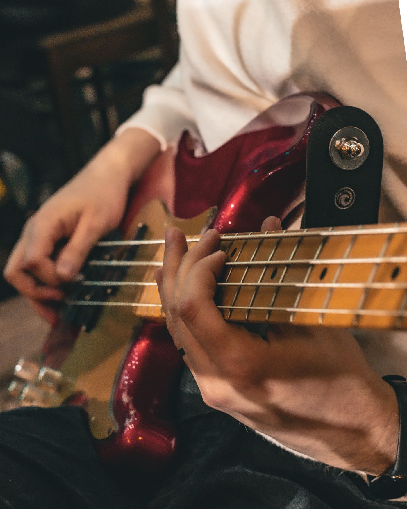Hände, die einen E-Bass greifen und zupfen