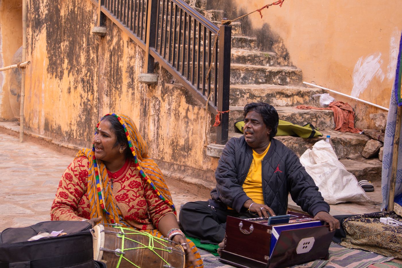 Musicisti di strada che suonano tamburi a mano e un harmonium all'aperto