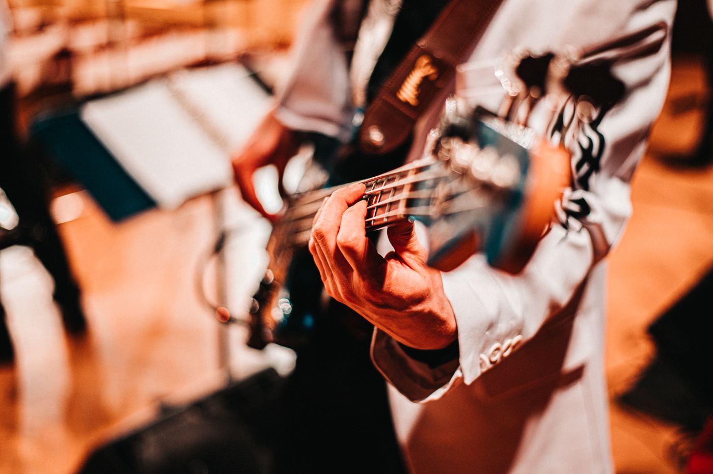 A musician fretting an electric bass guitar during a performance