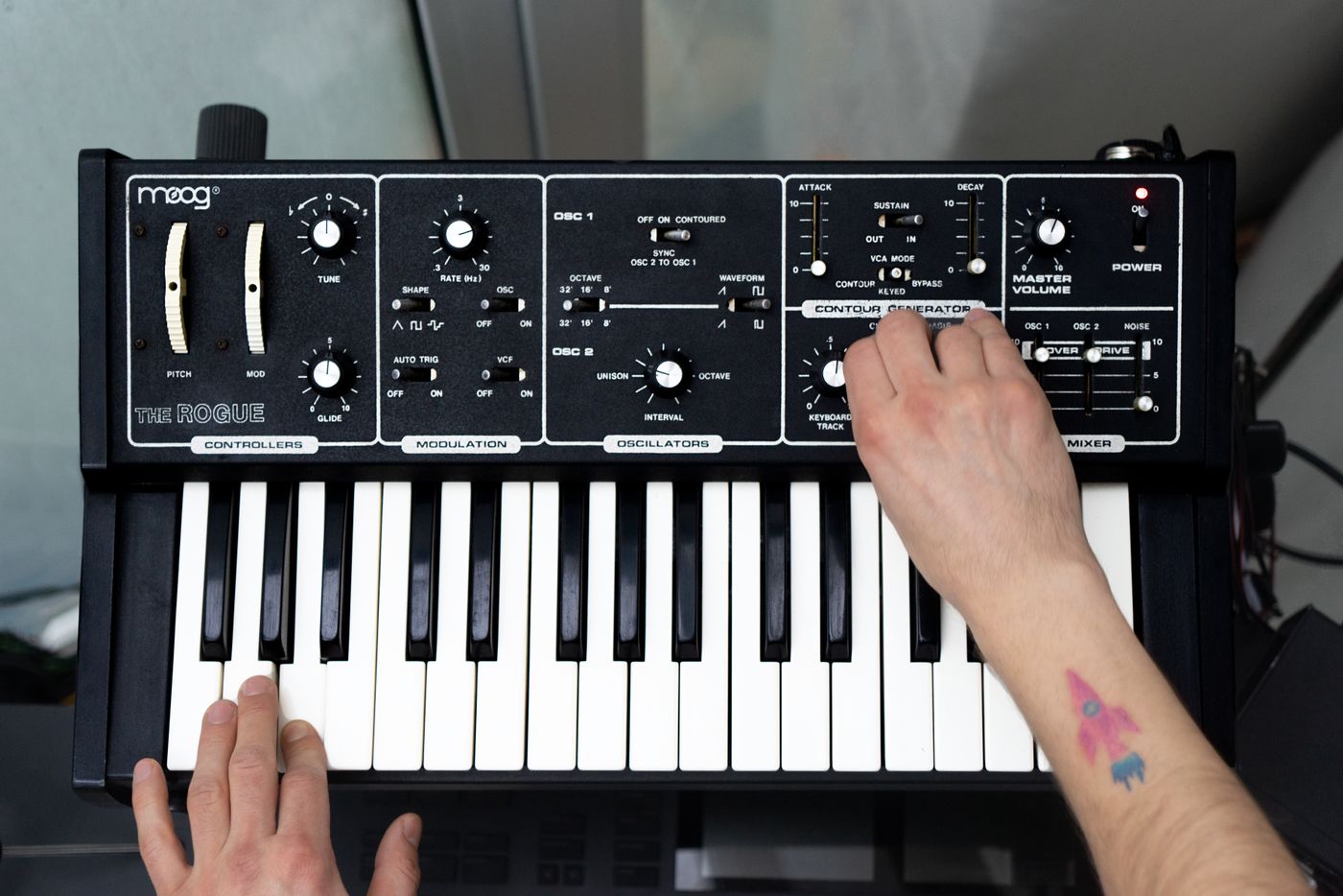 Hände spielen ein Synthesizer-Keyboard und dessen Bedienelemente