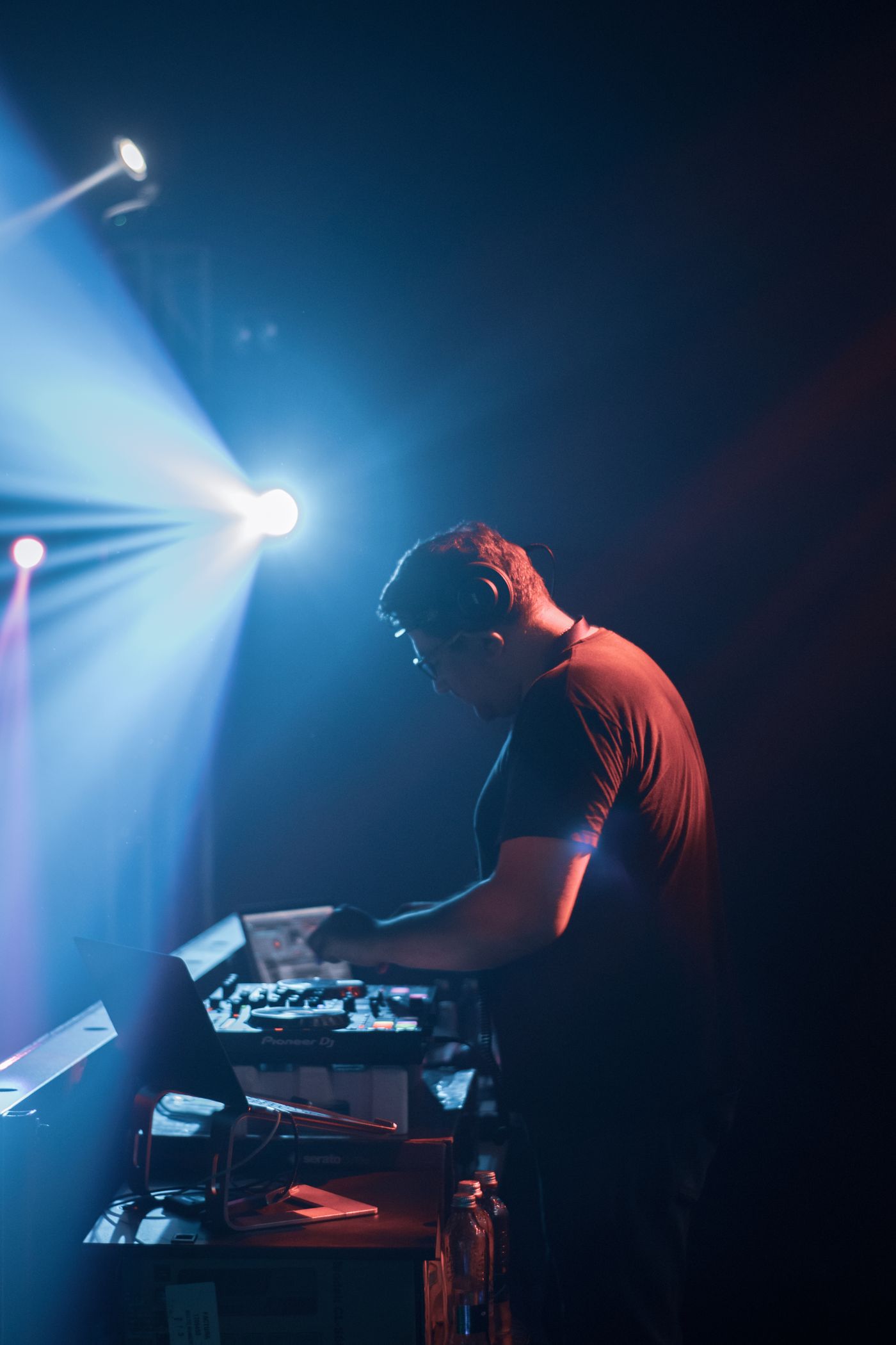 Ein DJ arbeitet unter Bühnenlichtern