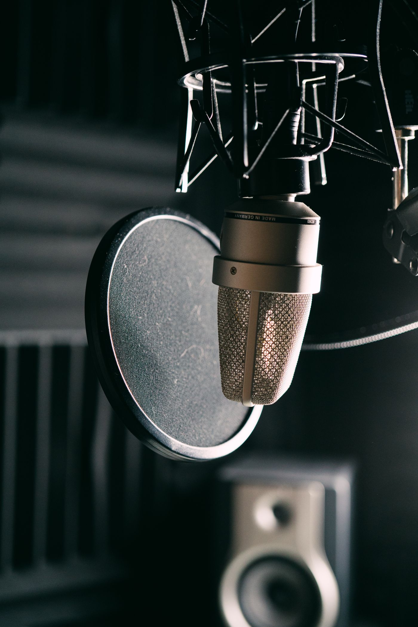 Ein Aufnahmemikrofon und Popschutz in einem dämmrigen Studio