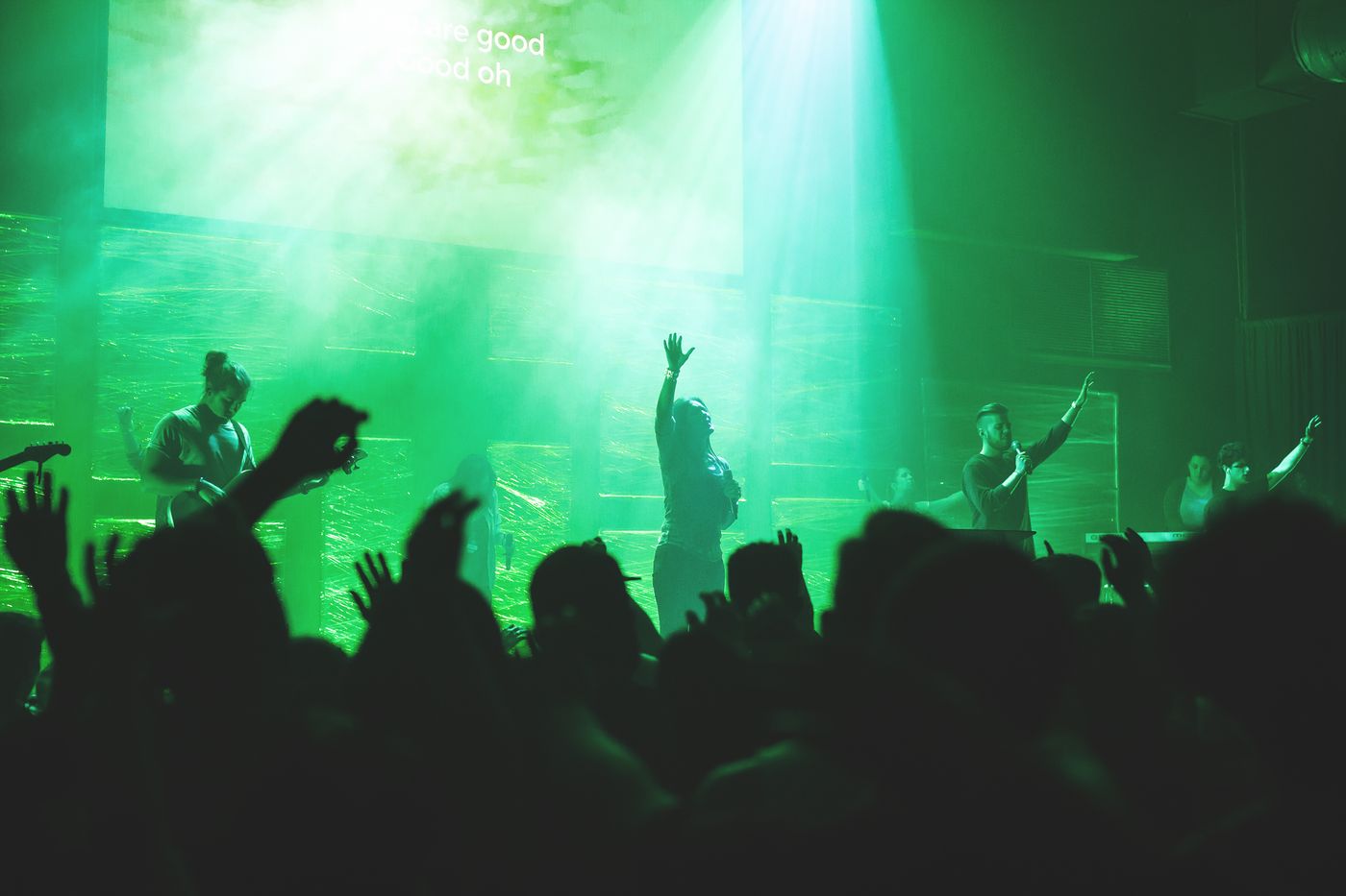 Worship-Band tritt auf einer Kirchenbühne vor Publikum auf.