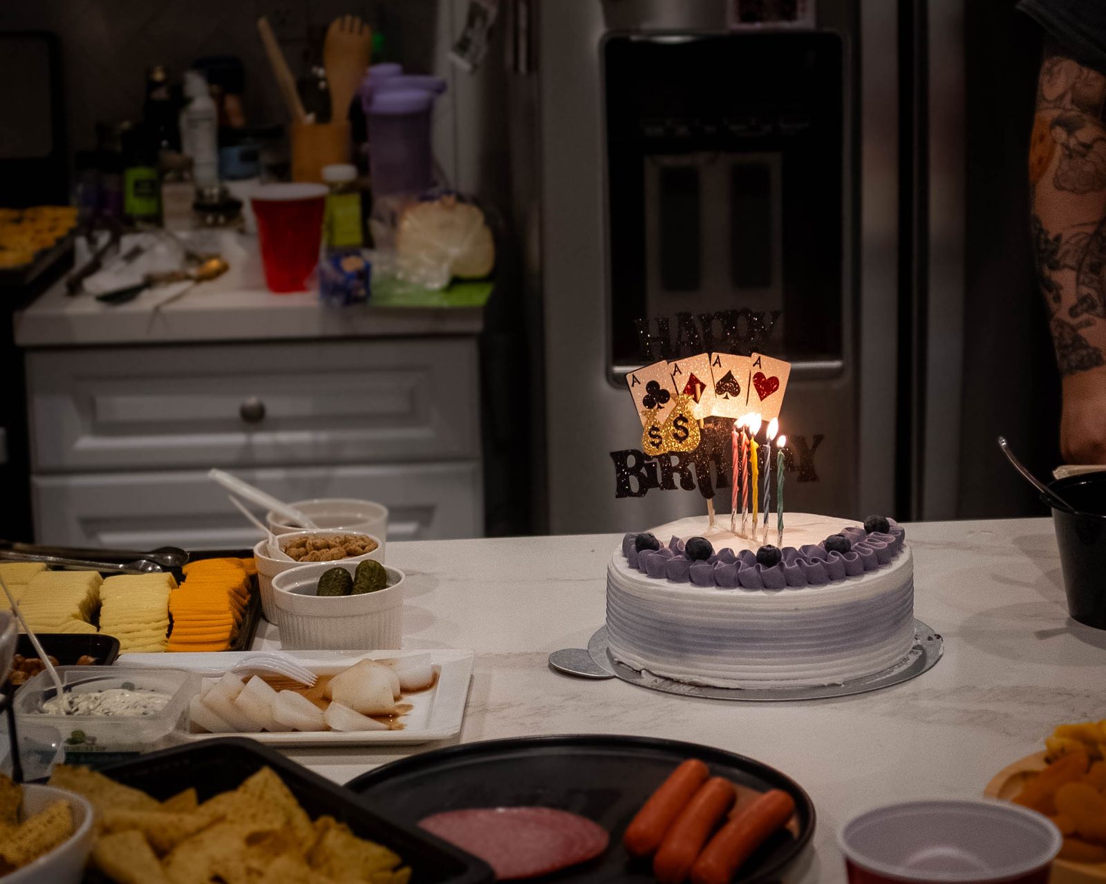 A birthday cake with lit candles on a celebration table