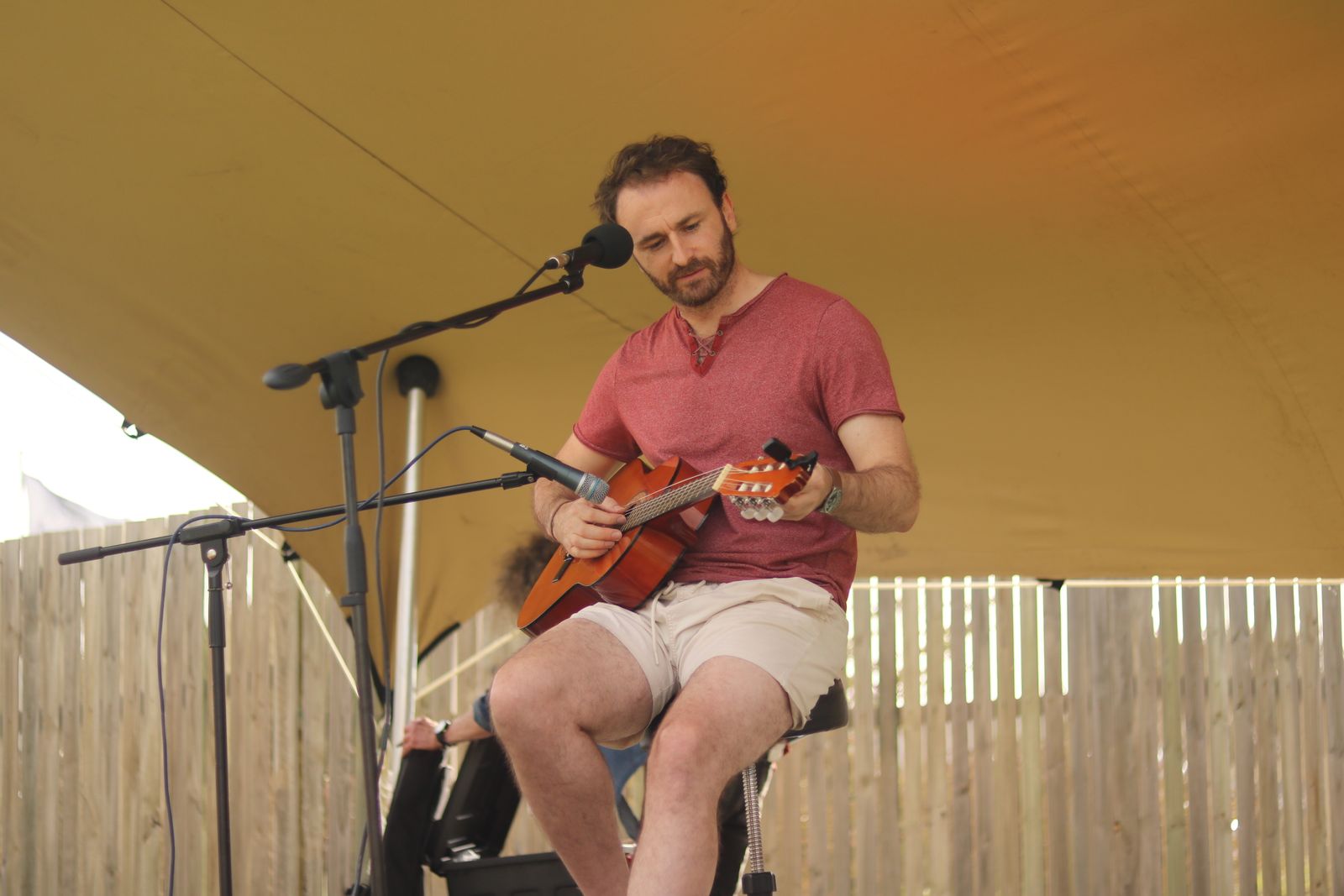 Ein Musiker spielt Akustikgitarre bei einer Veranstaltung im Freien
