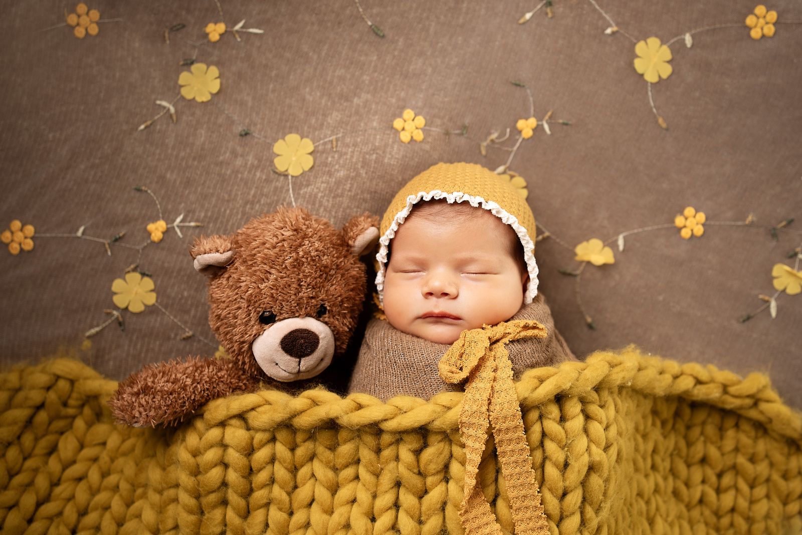 Ein schlafendes Baby, das neben einem kleinen Teddybären ruht