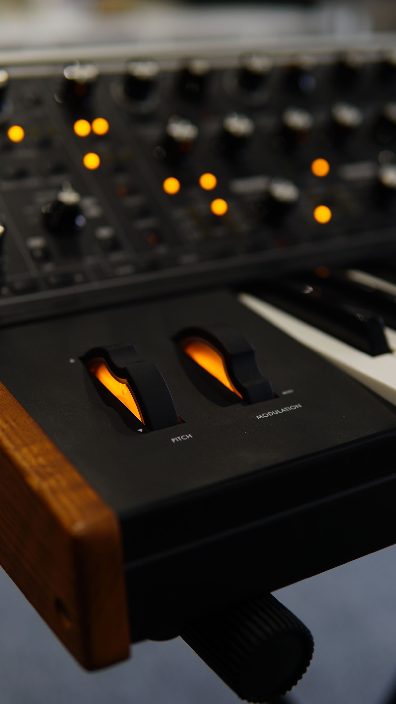 Eine Synthesizer-Tastatur und beleuchtete Studio-Bedienelemente