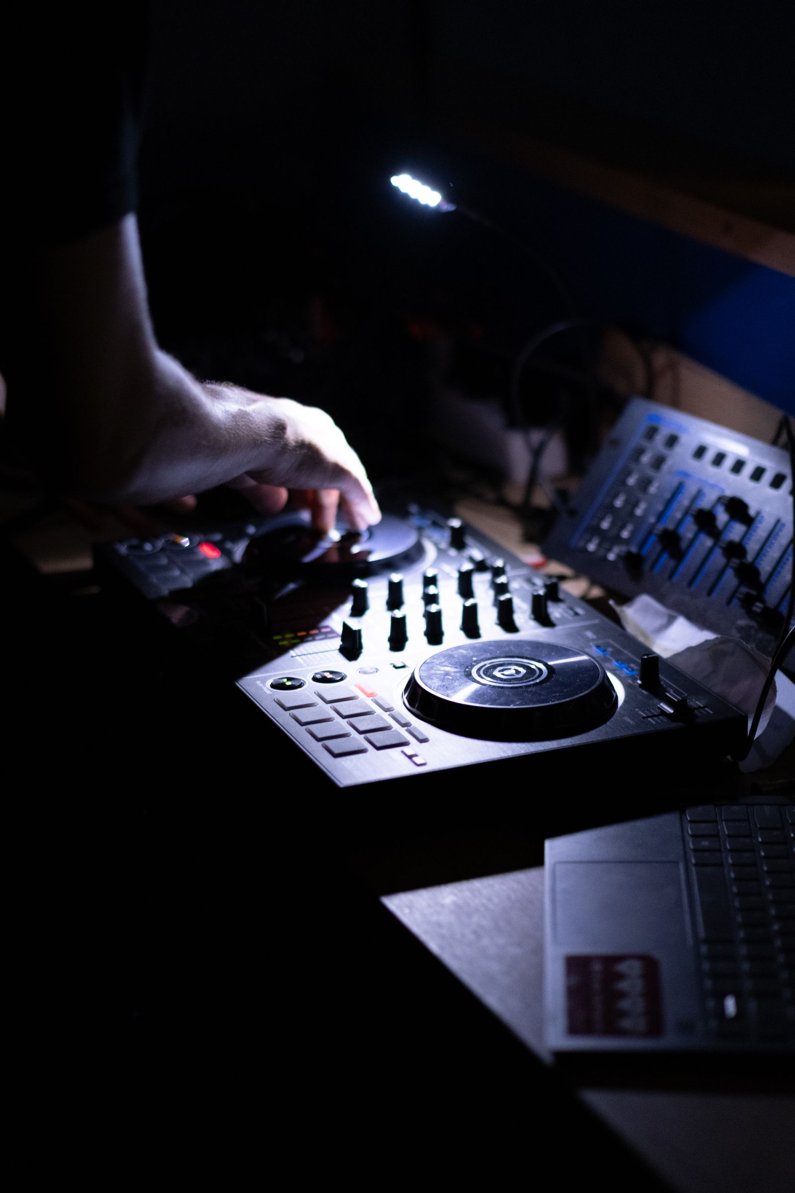 Hands working the controls of a music mixer