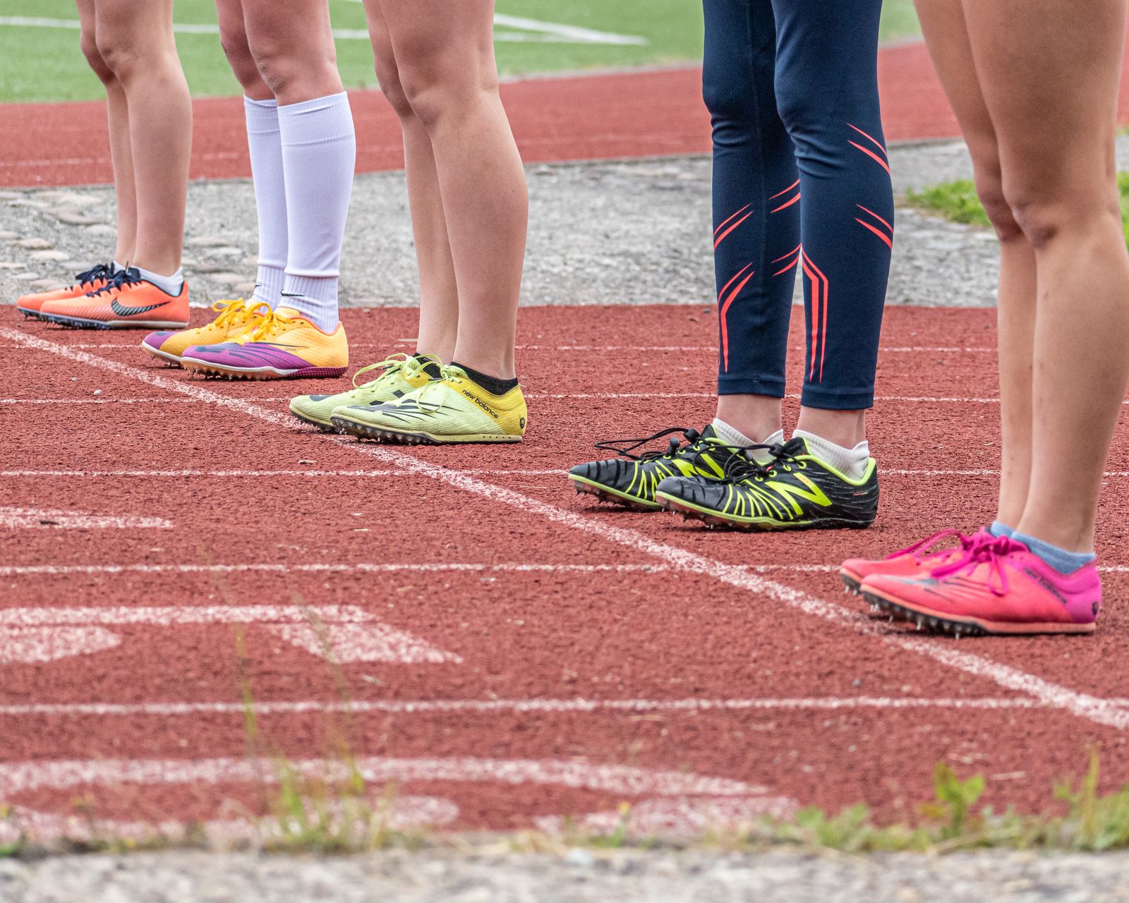 Corredores con zapatillas de correr de pie juntos en una pista